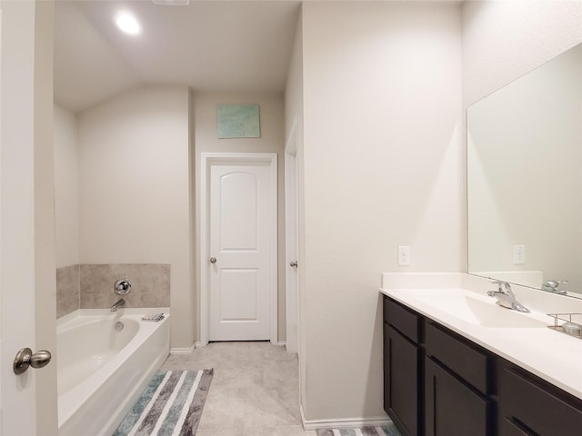 bathroom with tile patterned floors, vanity, lofted ceiling, and a tub to relax in