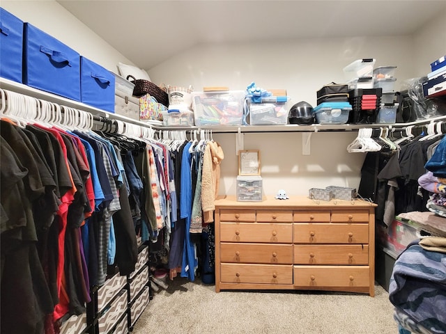 spacious closet featuring light colored carpet and vaulted ceiling