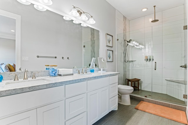 bathroom with hardwood / wood-style flooring, vanity, toilet, and a shower with door