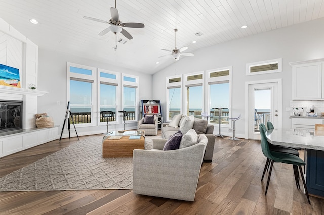 living room featuring dark hardwood / wood-style floors, ceiling fan, wooden ceiling, and a tiled fireplace