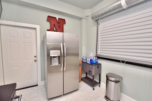 kitchen with light tile patterned flooring and stainless steel refrigerator with ice dispenser