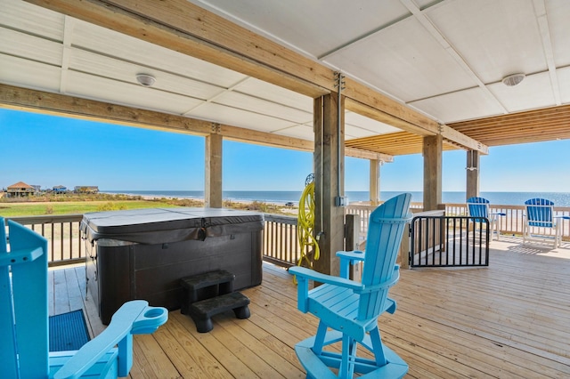 wooden deck with a water view and a hot tub