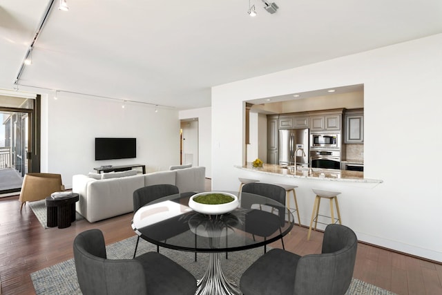 dining room featuring dark wood-type flooring and track lighting