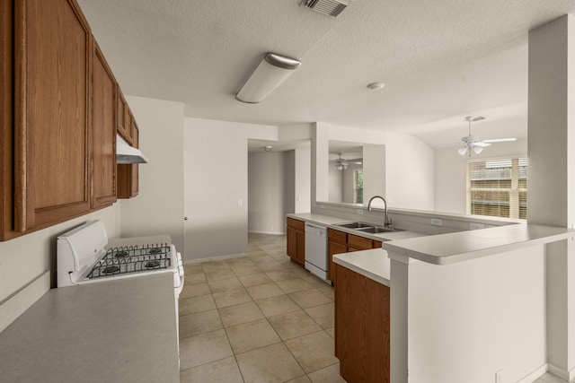 kitchen featuring kitchen peninsula, a textured ceiling, white appliances, and sink