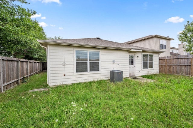 back of house featuring a yard and central AC unit