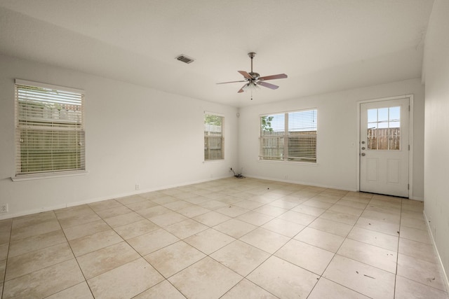 empty room with ceiling fan and light tile patterned floors