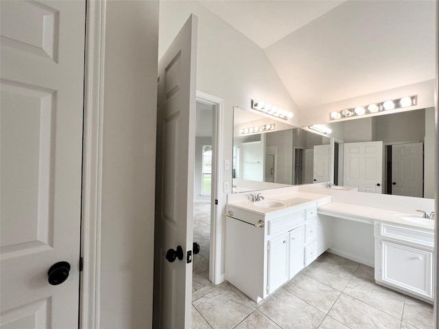 bathroom featuring tile patterned flooring, vanity, and vaulted ceiling