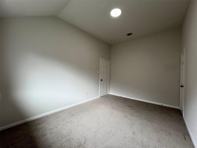 unfurnished room featuring carpet flooring and lofted ceiling