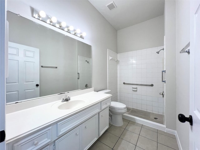 bathroom with tile patterned floors, vanity, toilet, and tiled shower