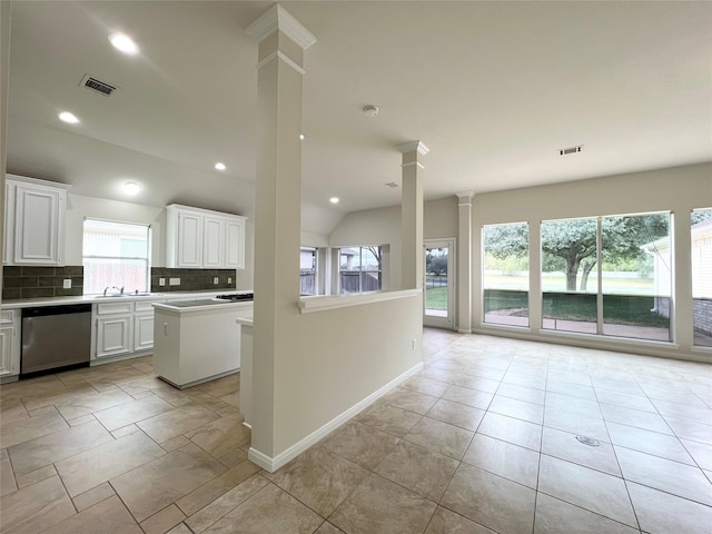 kitchen featuring backsplash, stainless steel dishwasher, sink, a center island, and white cabinetry