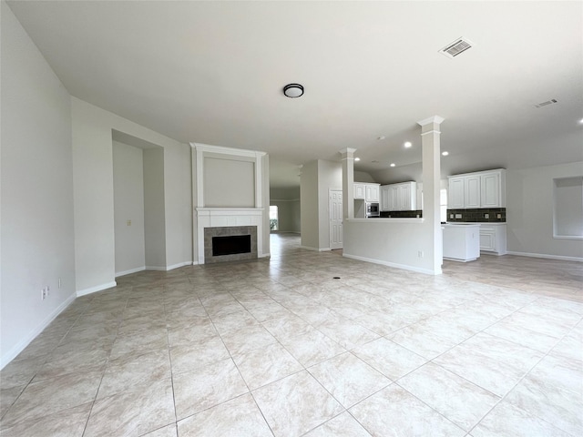 unfurnished living room featuring a tiled fireplace