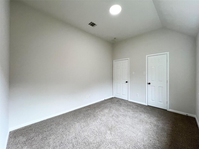 unfurnished bedroom featuring carpet and lofted ceiling