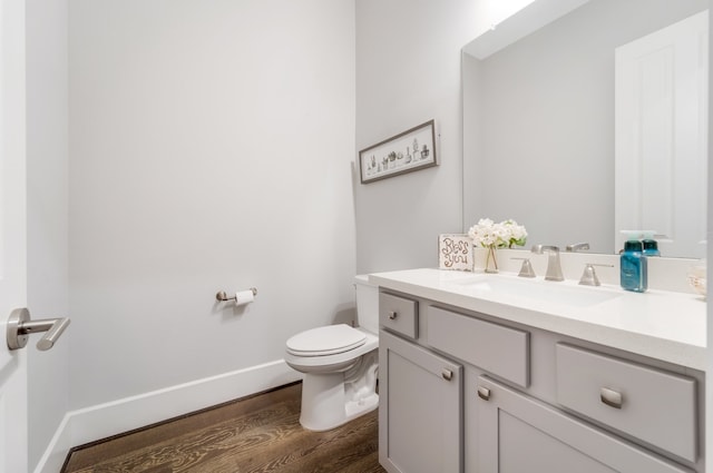 bathroom featuring wood-type flooring, vanity, and toilet