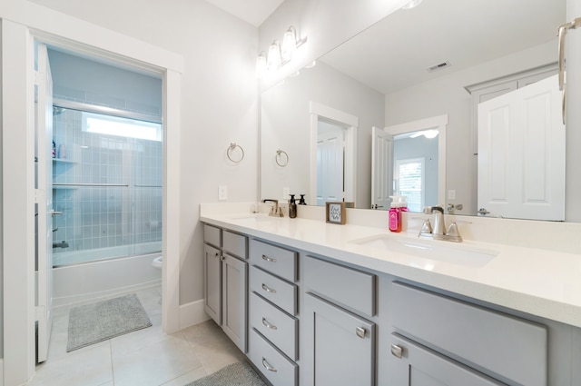 bathroom with tile patterned flooring, vanity, and bath / shower combo with glass door