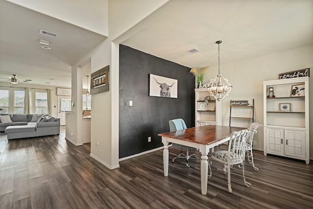 dining area with ceiling fan with notable chandelier and dark wood-type flooring