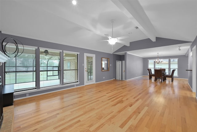 unfurnished living room featuring a wealth of natural light, light hardwood / wood-style flooring, lofted ceiling with beams, and ceiling fan with notable chandelier