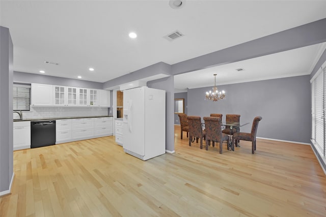 kitchen featuring ornamental molding, white refrigerator with ice dispenser, black dishwasher, light hardwood / wood-style floors, and white cabinetry