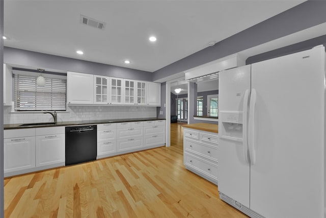 kitchen with dishwasher, white fridge with ice dispenser, sink, light hardwood / wood-style flooring, and white cabinets