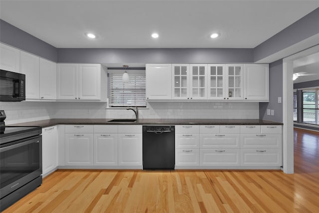 kitchen with black appliances, light hardwood / wood-style floors, white cabinets, and sink