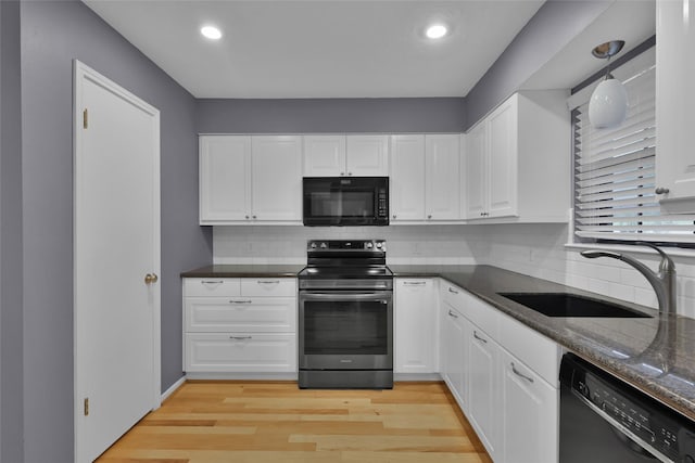 kitchen featuring sink, light hardwood / wood-style floors, white cabinetry, and black appliances