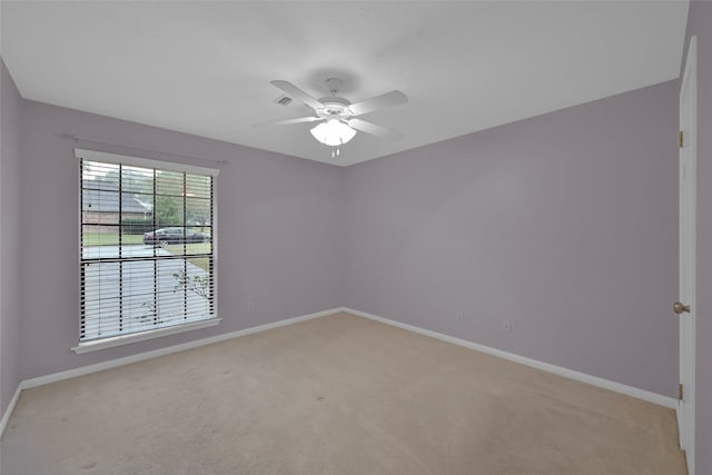 empty room featuring ceiling fan and light colored carpet