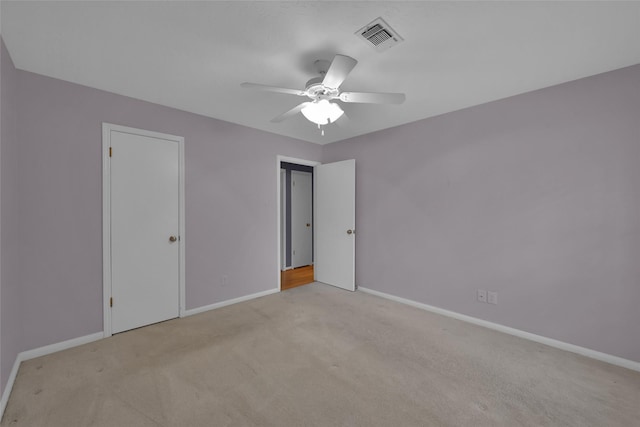 unfurnished bedroom with a closet, light colored carpet, and ceiling fan