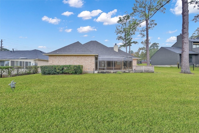 back of property featuring a lawn and a sunroom