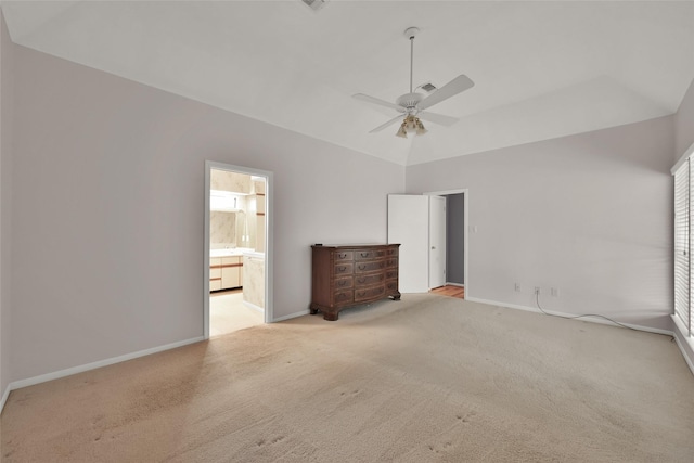 unfurnished bedroom with ceiling fan, light colored carpet, lofted ceiling, and ensuite bathroom