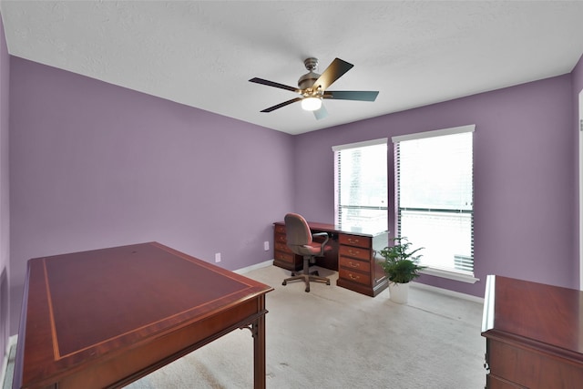 home office with ceiling fan, light colored carpet, and a textured ceiling