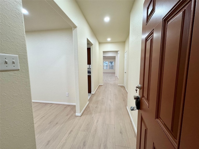 corridor with light hardwood / wood-style floors