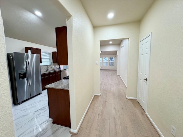 corridor with light hardwood / wood-style floors and sink