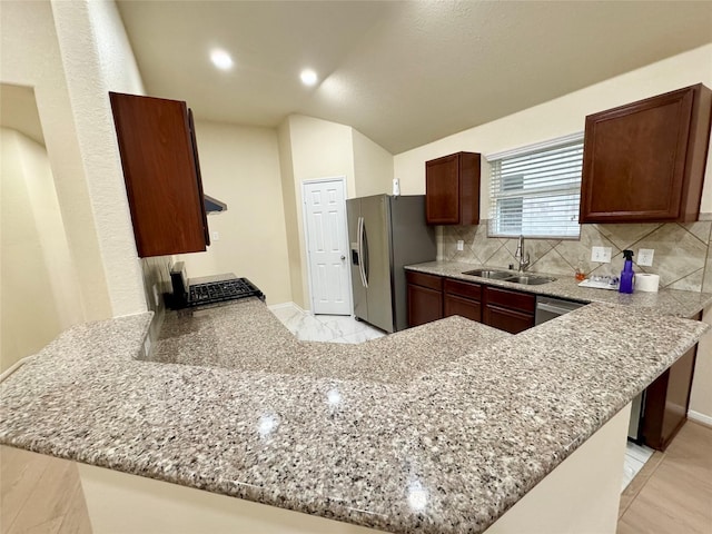 kitchen featuring kitchen peninsula, sink, and stainless steel refrigerator with ice dispenser