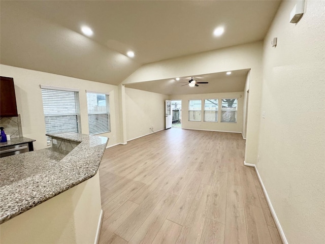 living room featuring ceiling fan, light hardwood / wood-style flooring, and vaulted ceiling