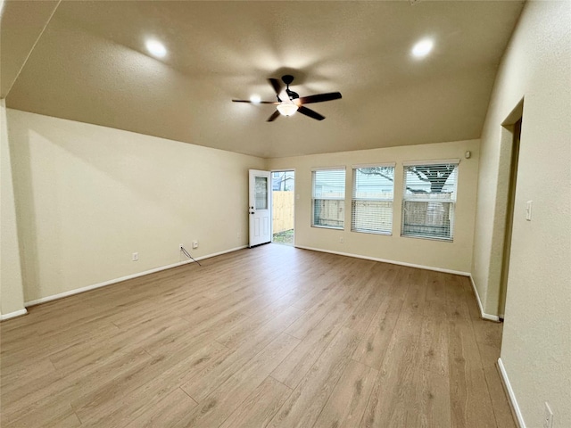 empty room featuring ceiling fan, lofted ceiling, and light wood-type flooring