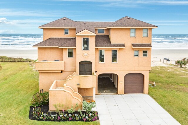 view of front of property with a front yard, a water view, and a garage