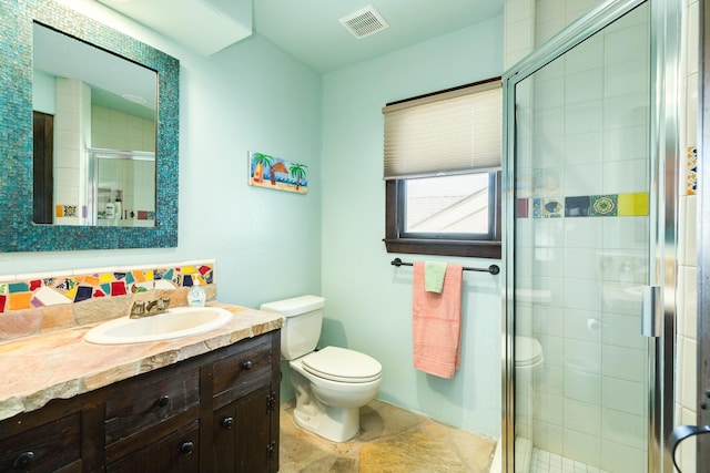 bathroom with vanity, toilet, and a shower with shower door