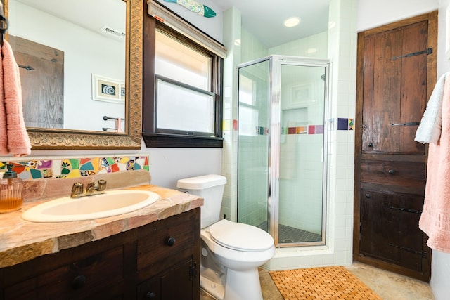 bathroom with toilet, vanity, tile patterned floors, and a shower with door