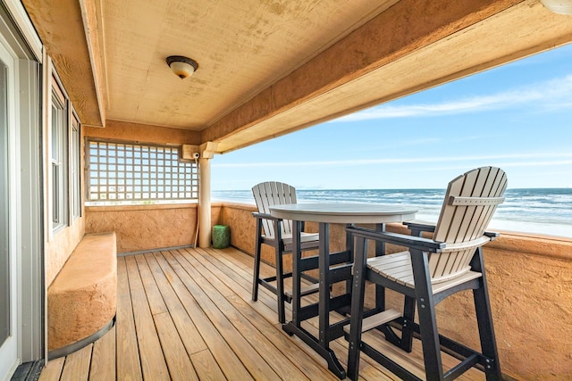 balcony with a water view and a view of the beach