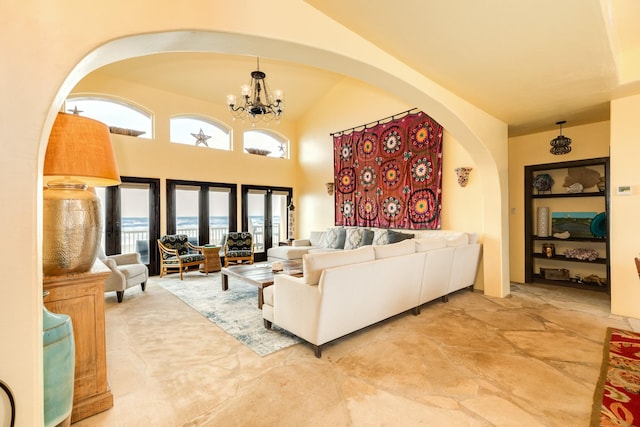 living room featuring french doors, lofted ceiling, and a notable chandelier