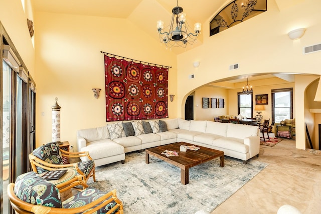 living room featuring high vaulted ceiling and a notable chandelier