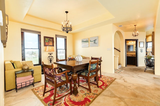 dining room with a tray ceiling and a chandelier