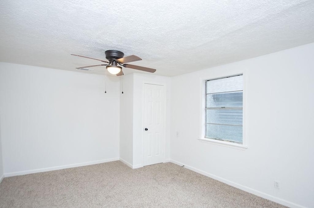 unfurnished room featuring a textured ceiling, light colored carpet, and ceiling fan