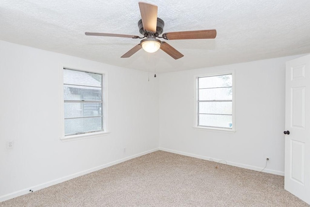 spare room featuring ceiling fan, a textured ceiling, plenty of natural light, and carpet flooring