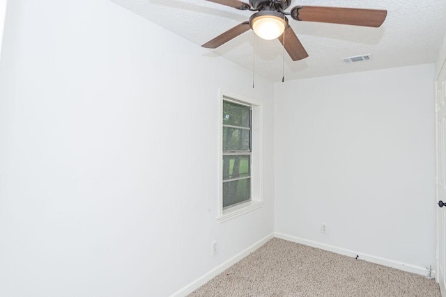 empty room featuring a textured ceiling and light carpet