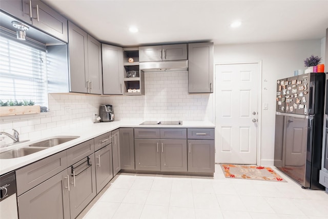 kitchen featuring backsplash, sink, stainless steel fridge, gray cabinets, and dishwashing machine