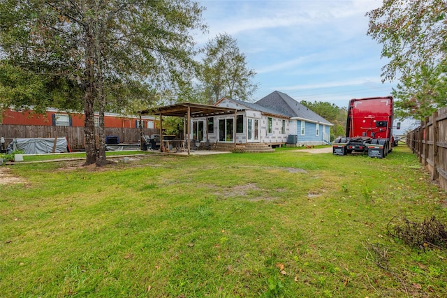 rear view of house featuring a lawn and central AC unit