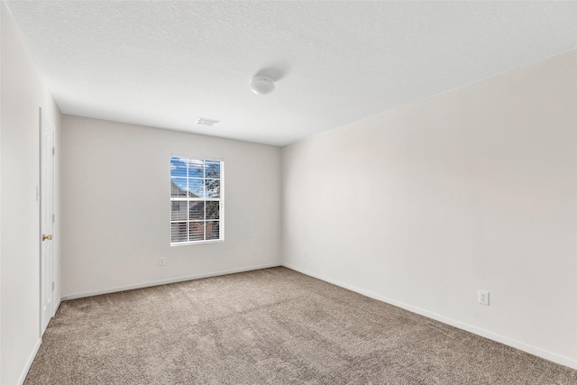 unfurnished room with carpet flooring and a textured ceiling