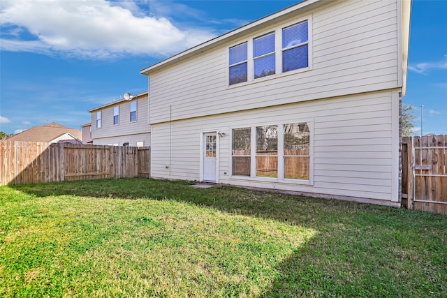 back of house with a lawn