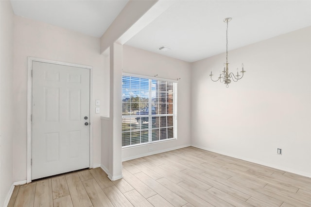 foyer featuring an inviting chandelier and light hardwood / wood-style flooring