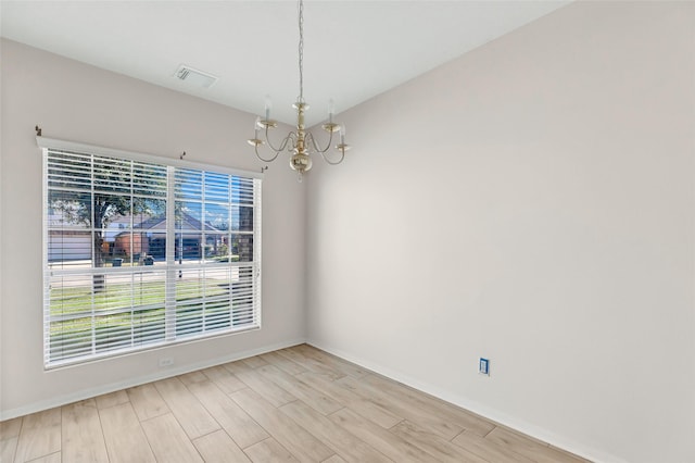 unfurnished dining area featuring light wood-type flooring and a chandelier